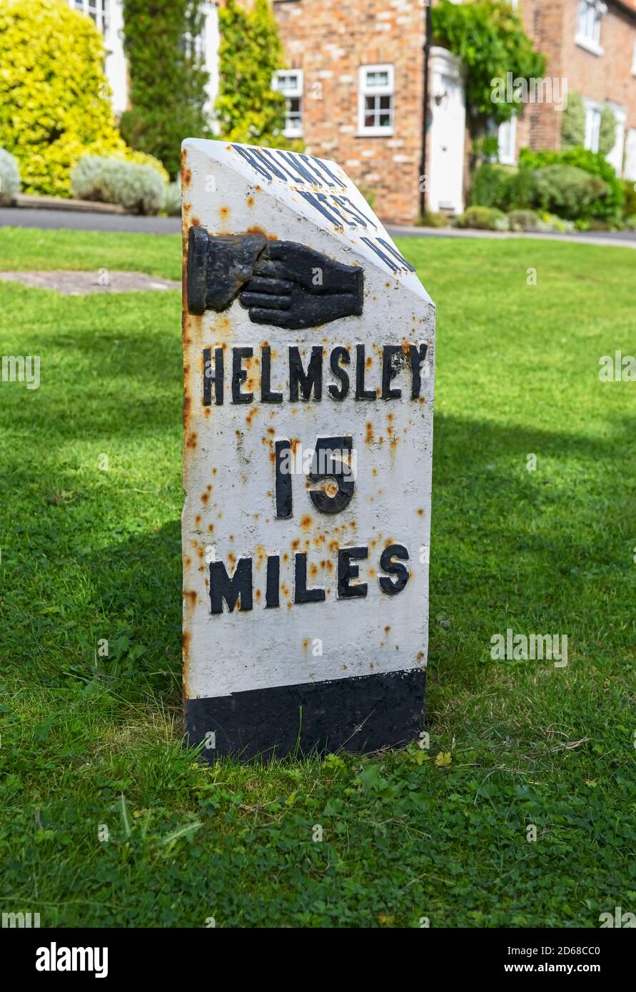 Close up of old black and white painted milepost road sign to Helmsley North Yorkshire England UK United Kingdom GB Great Britain Stock Photo