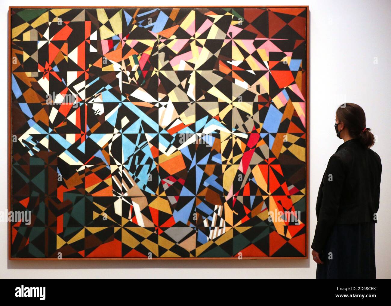 A Tate employee looks at David Bomberg's work 'In the Hold' during a photocall for the new collection displays at Tate Britain in London. Stock Photo