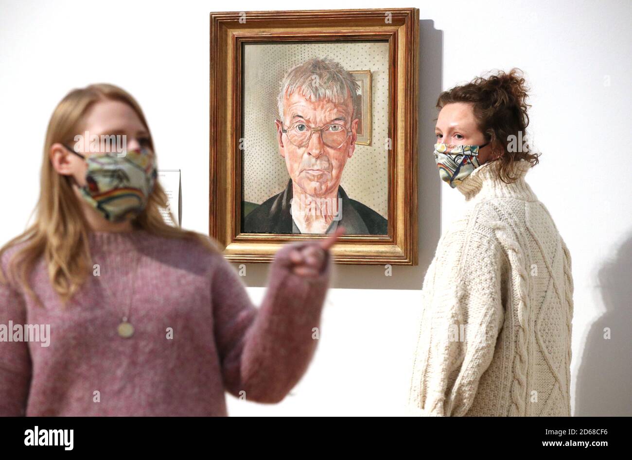 Tate employees stand before a self portrait by Sir Stanley Spencer during a photocall for the new collection displays at Tate Britain in London. Stock Photo