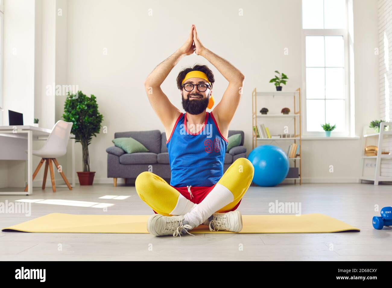 Funny man sitting in easy yoga pose with arms raised, learning to do  breathing exercise and meditate Stock Photo - Alamy