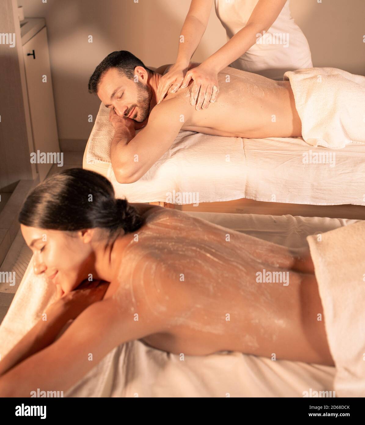 Exfoliate older skin with a body scrub. time for pampering body and skin at spa. Couple getting peel procedure after body massage. Stock Photo