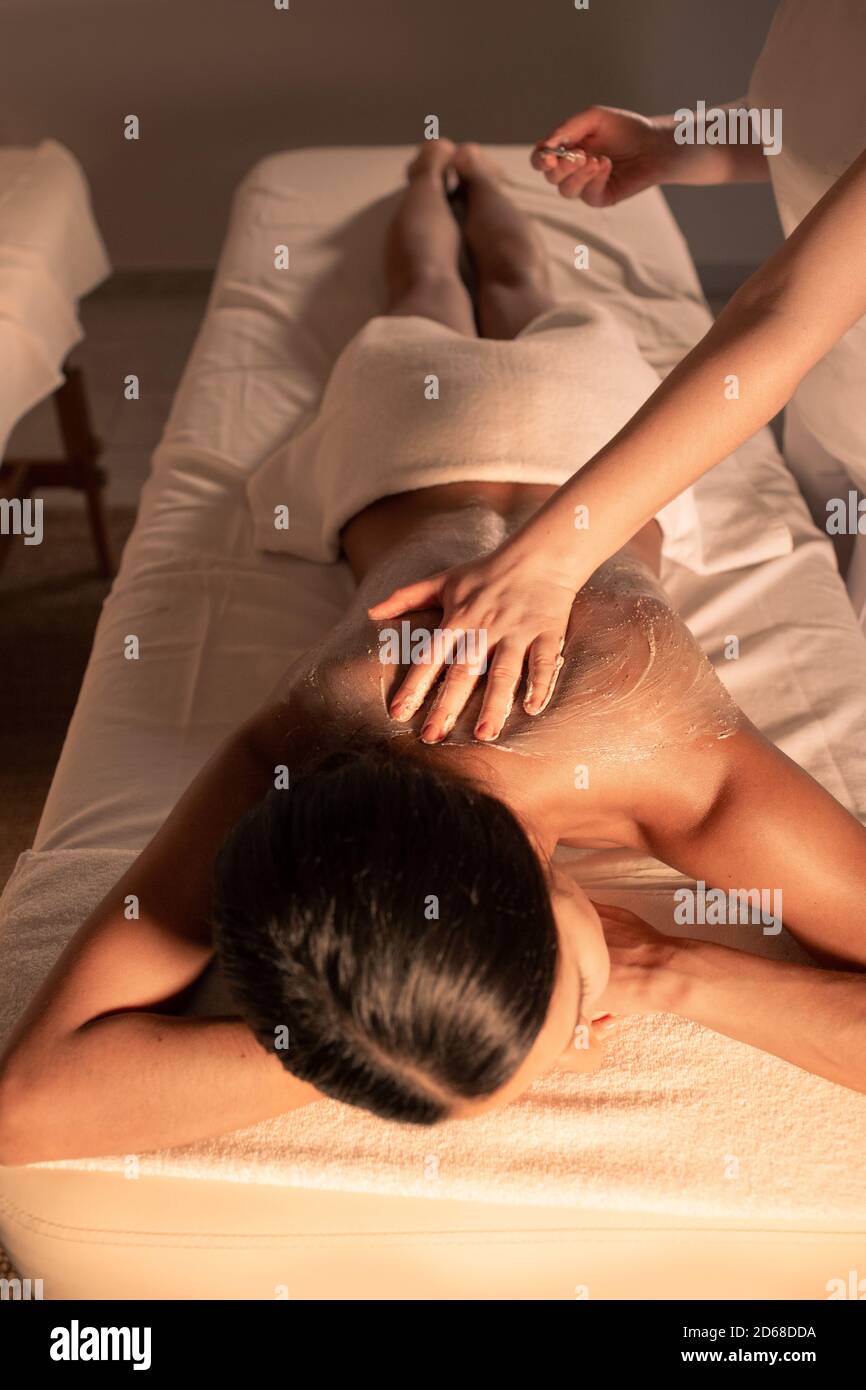 beautiful woman during body peeling at spa. Enjoys skin peeling, skin cleansing and renewal Stock Photo
