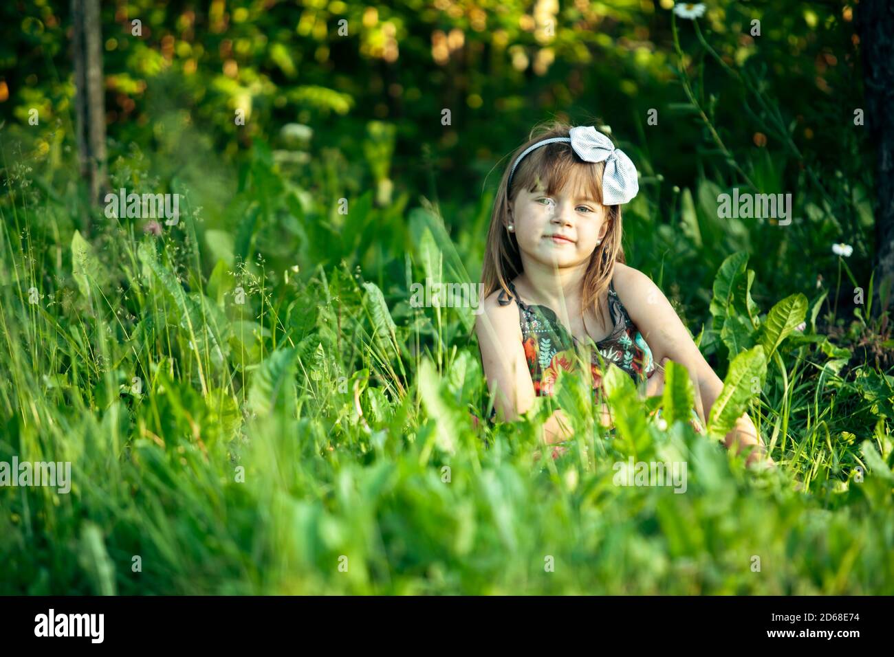 Little cute girl playing in the green grass Stock Photo - Alamy