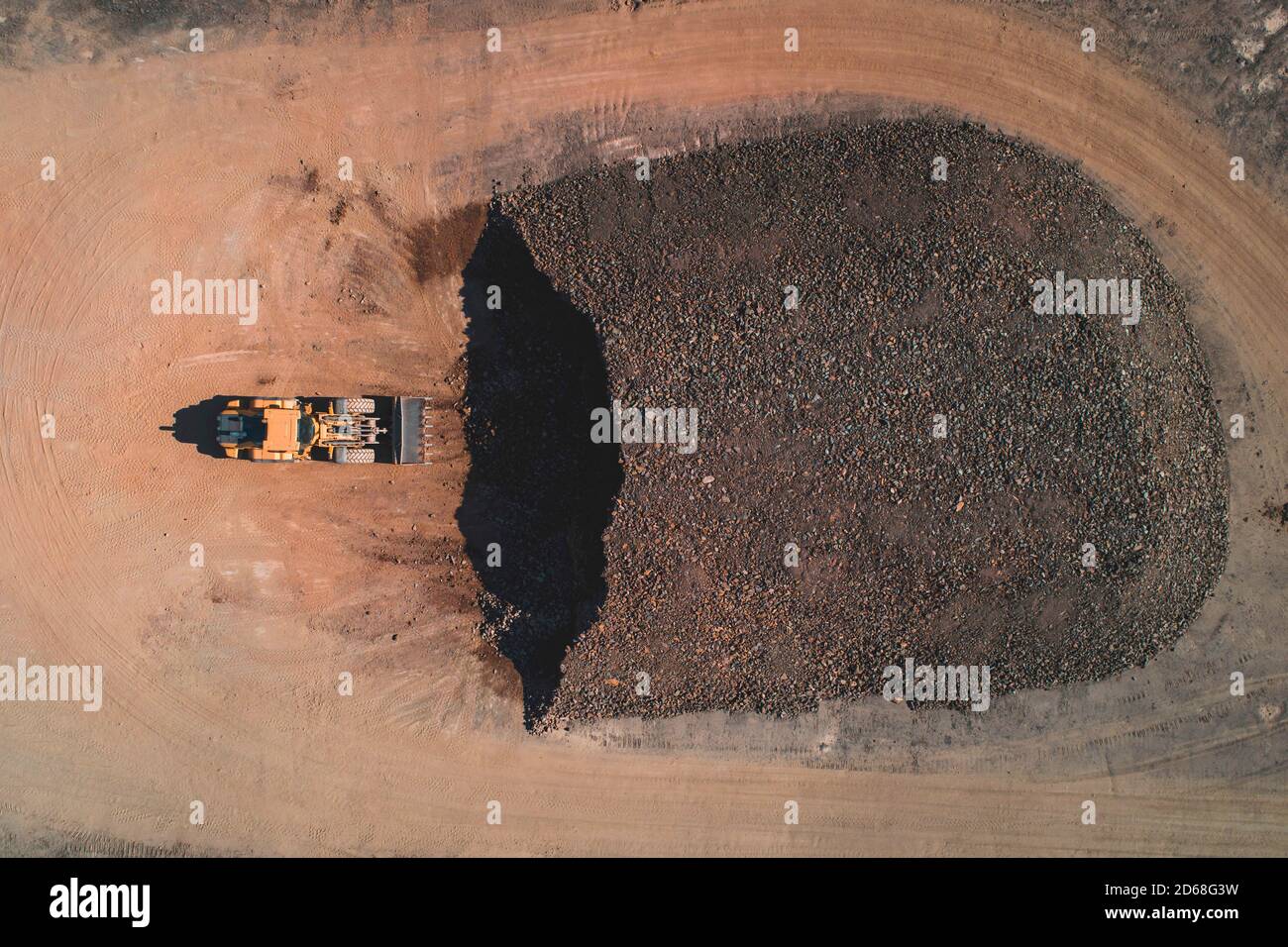 Aerial view of a digger in a quarry in front of a pile of rubble Stock Photo