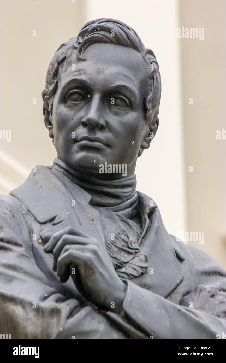 The Stamford Raffles statue in front of the Victoria Memorial Hall and Theatre, sculpted by Thomas Woolner, is a popular icon of Singapore. Stock Photo