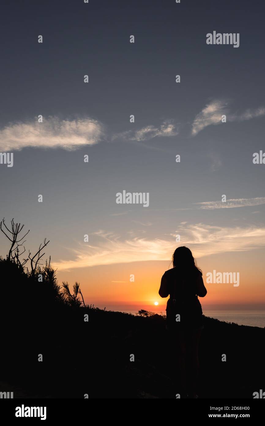 Silhouette of a woman watching the sunset. Golden Hour Stock Photo - Alamy