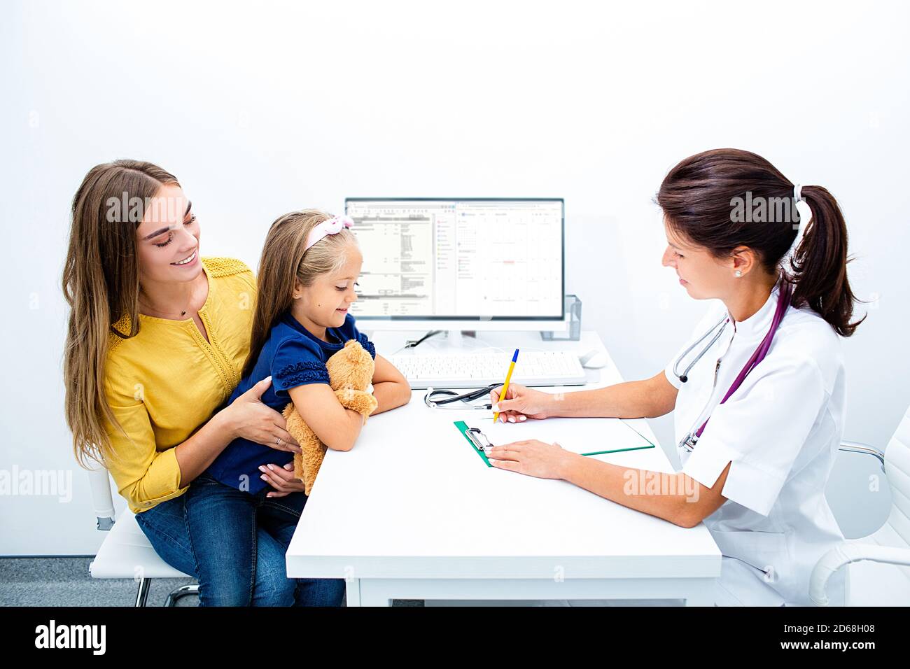 Friendly pediatrician meeting with parent and child in the hospital. Consultation, kid health. Stock Photo