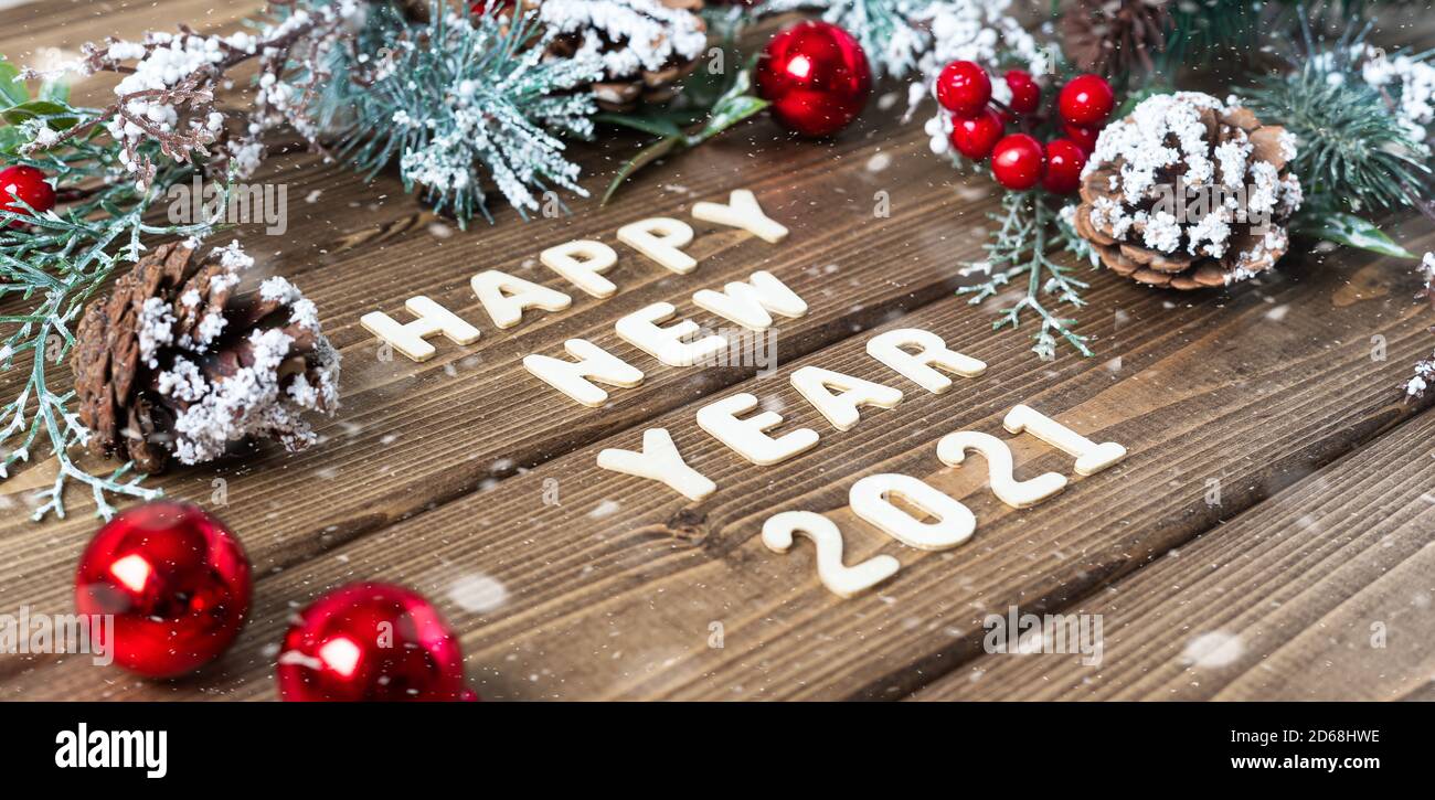 Happy new year 2021 composition. Christmas fir branches decorations on old dark wooden background with letters text, flat lay side view Stock Photo