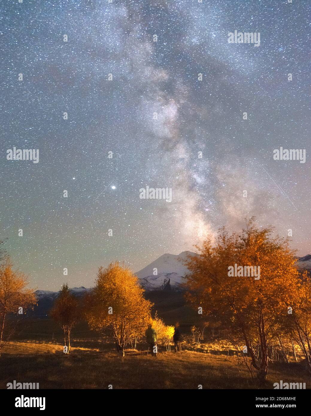 Milky Way in the sky over Mount Elbrus and orange autumn trees Stock Photo