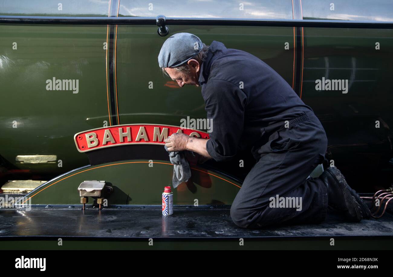 The name plate for the LMS Jubilee class 4-6-0 steam locomotive 45596, ???Bahamas??? is cleaned whilst at light steam at Ropley station ahead of this weekend's Autumn Steam Gala on the Mid Hants Railway's Watercress Line. Stock Photo