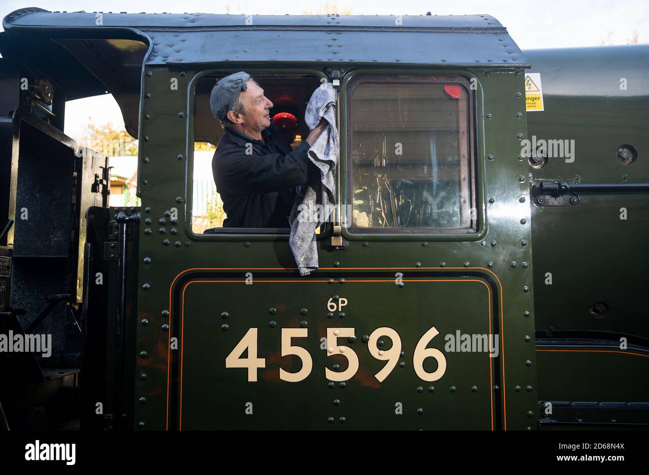 The cab window for the LMS Jubilee class 4-6-0 steam locomotive 45596, ???Bahamas??? is cleaned whilst at light steam at Ropley station ahead of this weekend's Autumn Steam Gala on the Mid Hants Railway's Watercress Line. Stock Photo