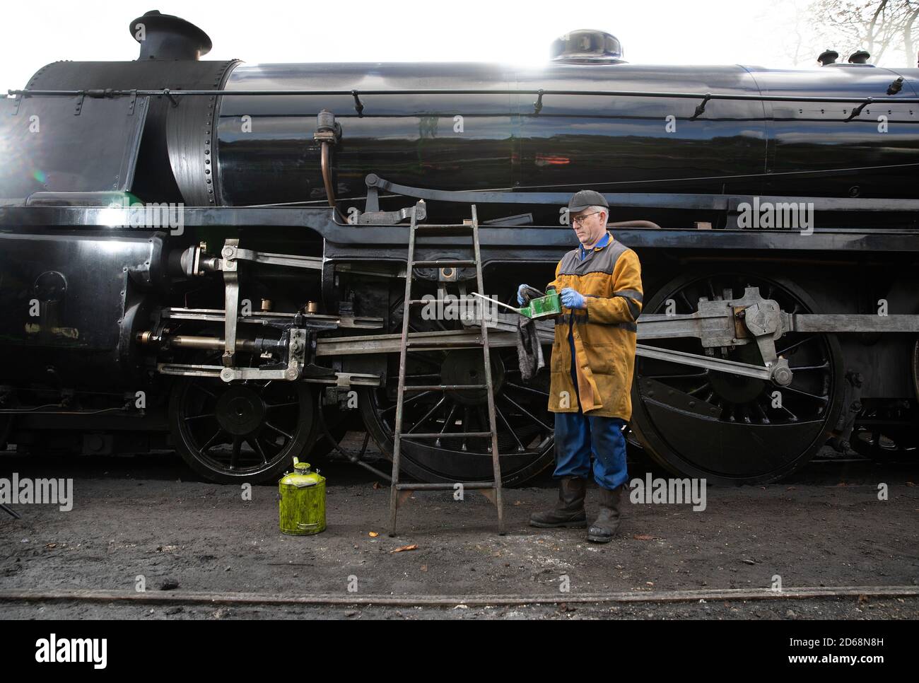 A volunteer oils on the S15 class steam locomotive 506 at Ropley station ahead of this weekend's Autumn Steam Gala on the Mid Hants Railway's Watercress Line. Stock Photo