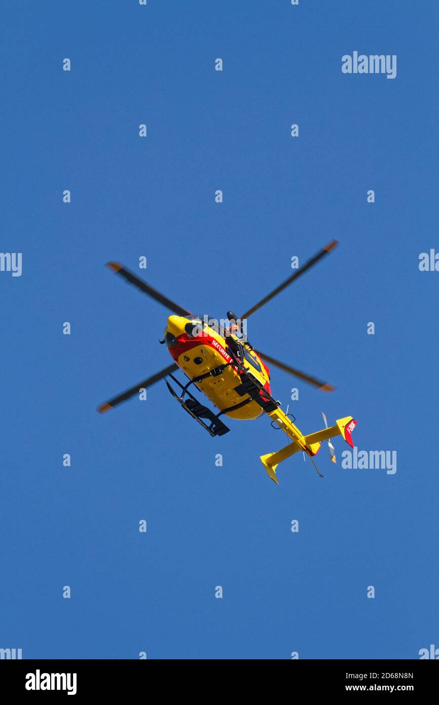 CHAMROUSSE, FRANCE, September 18, 2020 : A group of Civil Security rescuers are training to recover a wounded man in the mountains under an helicopter Stock Photo