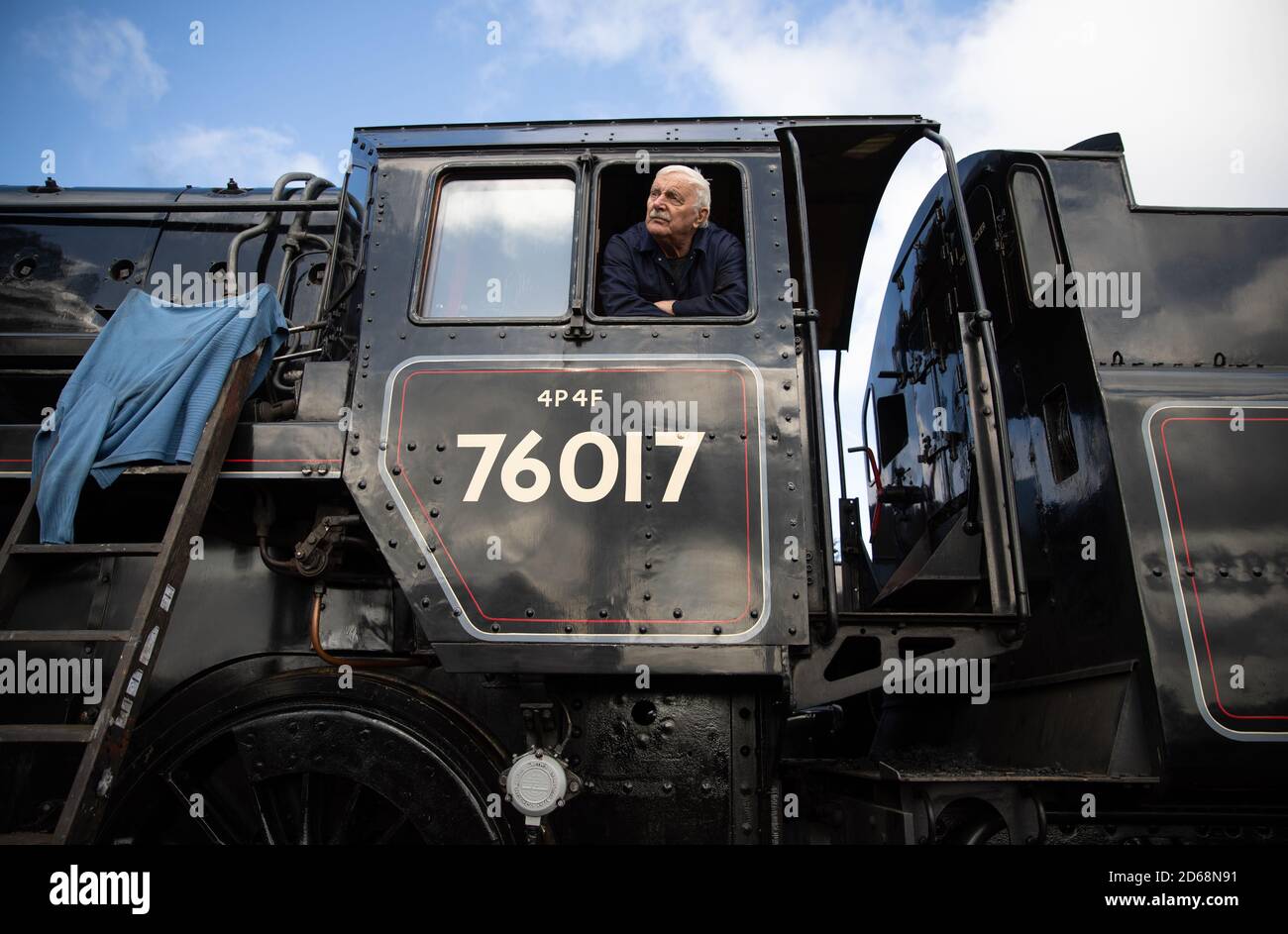 Driver Dave Pallett, who has volunteered on the Mid Hants Railway for over 25 years, looks out of the cab of the British Railways Standard Class 4MT steam locomotive 76017 as he poses for a photograph at Ropley station, ahead of this weekend's Autumn Steam Gala on the Mid Hants Railway's Watercress Line. Stock Photo