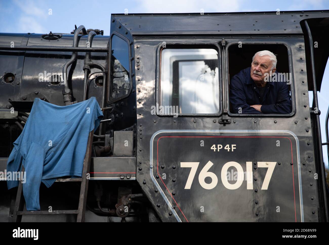 Driver Dave Pallett, who has volunteered on the Mid Hants Railway for over 25 years, looks out of the cab of the British Railways Standard Class 4MT steam locomotive 76017 as he poses for a photograph at Ropley station, ahead of this weekend's Autumn Steam Gala on the Mid Hants Railway's Watercress Line. Stock Photo
