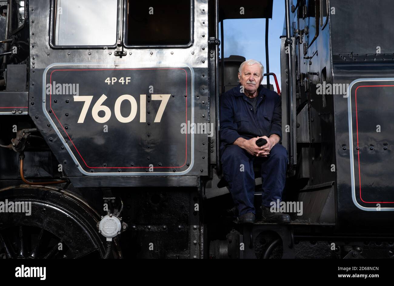 Driver Dave Pallett, who has volunteered on the Mid Hants Railway for over 25 years, looks out of the cab of the British Railways Standard Class 4MT steam locomotive 76017 as he poses for a photograph at Ropley station, ahead of this weekend's Autumn Steam Gala on the Mid Hants Railway's Watercress Line. Stock Photo