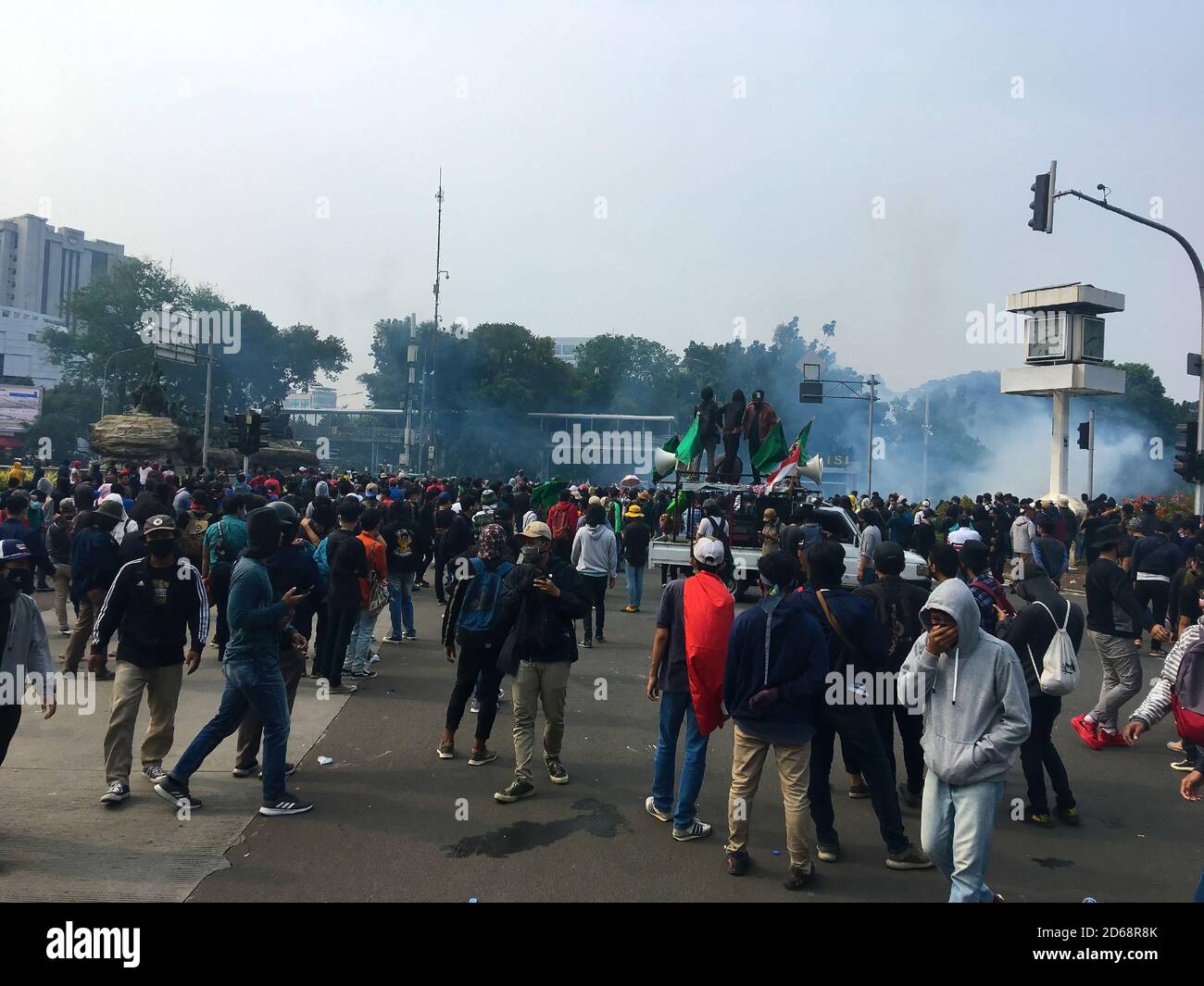 Protestor moving avoiding tear gas near Arjuna Wiwaha monument. Stock Photo