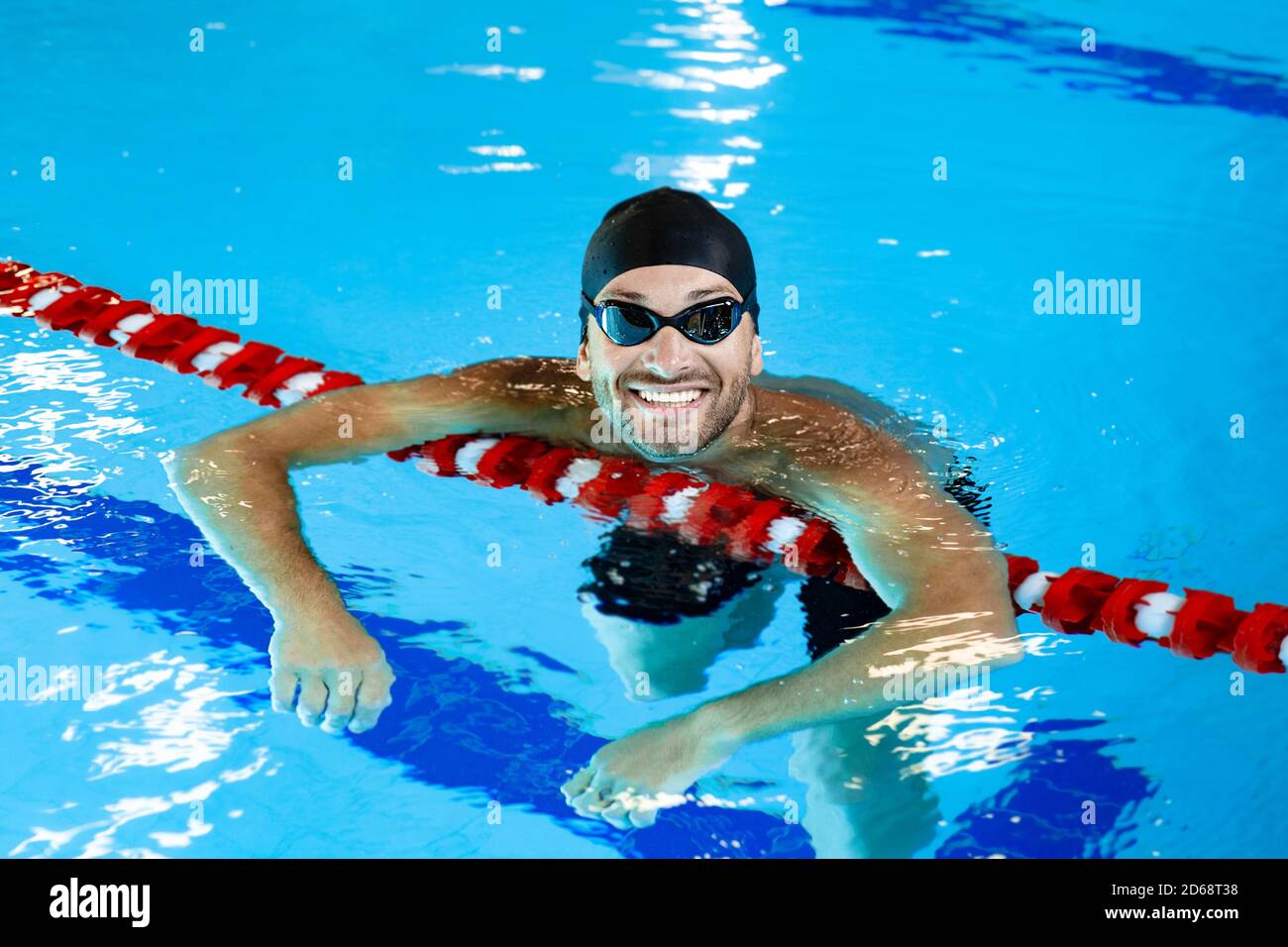 Portrait of a positive professional swimmer in a pool resting after