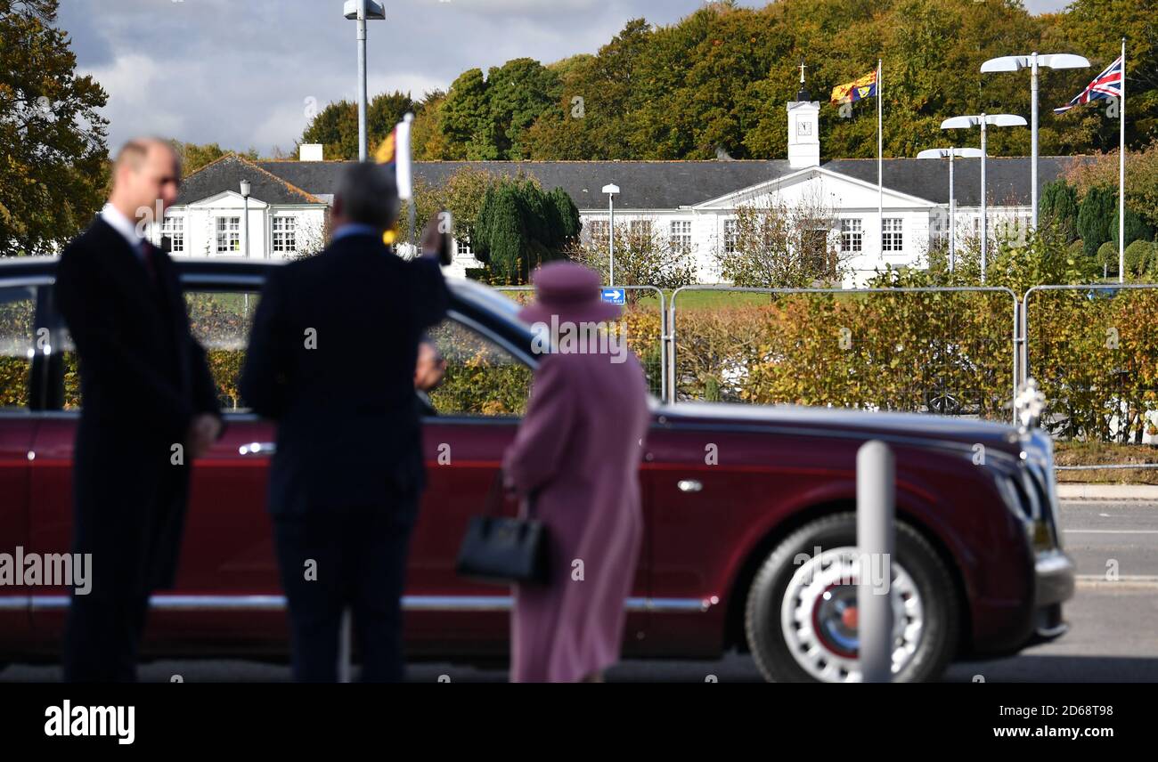 Chief Executive Gary Aitkenhead (centre) shows Queen Elizabeth II and the Duke of Cambridge (left) the Royal Standard flying over their buildings during their visit to the Defence Science and Technology Laboratory (DSTL) at Porton Down, Wiltshire. Stock Photo