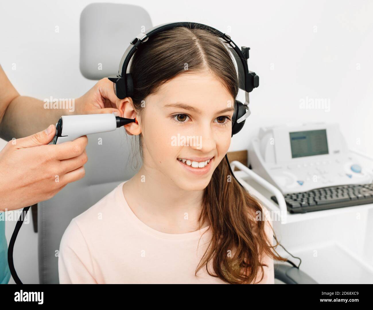 Audiologist is doing a hearing exam on a girl. Impedance audiometry. Methods for testing the middle ear in a child Stock Photo