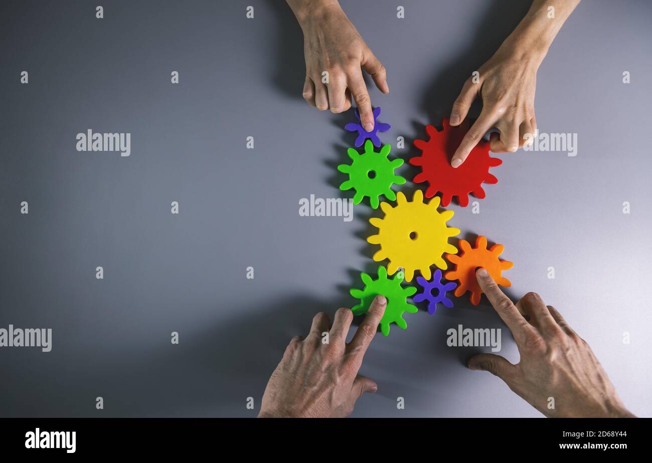 business development, teamwork and collaboration concept - people connecting gears. top view copy space Stock Photo