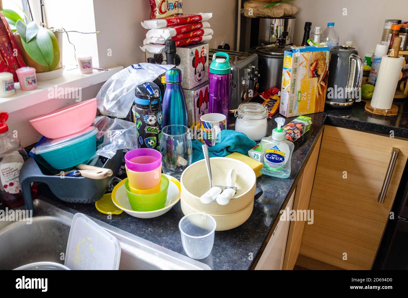 Washing up and cereal boxes, messy on a kitchen wortop. Stock Photo