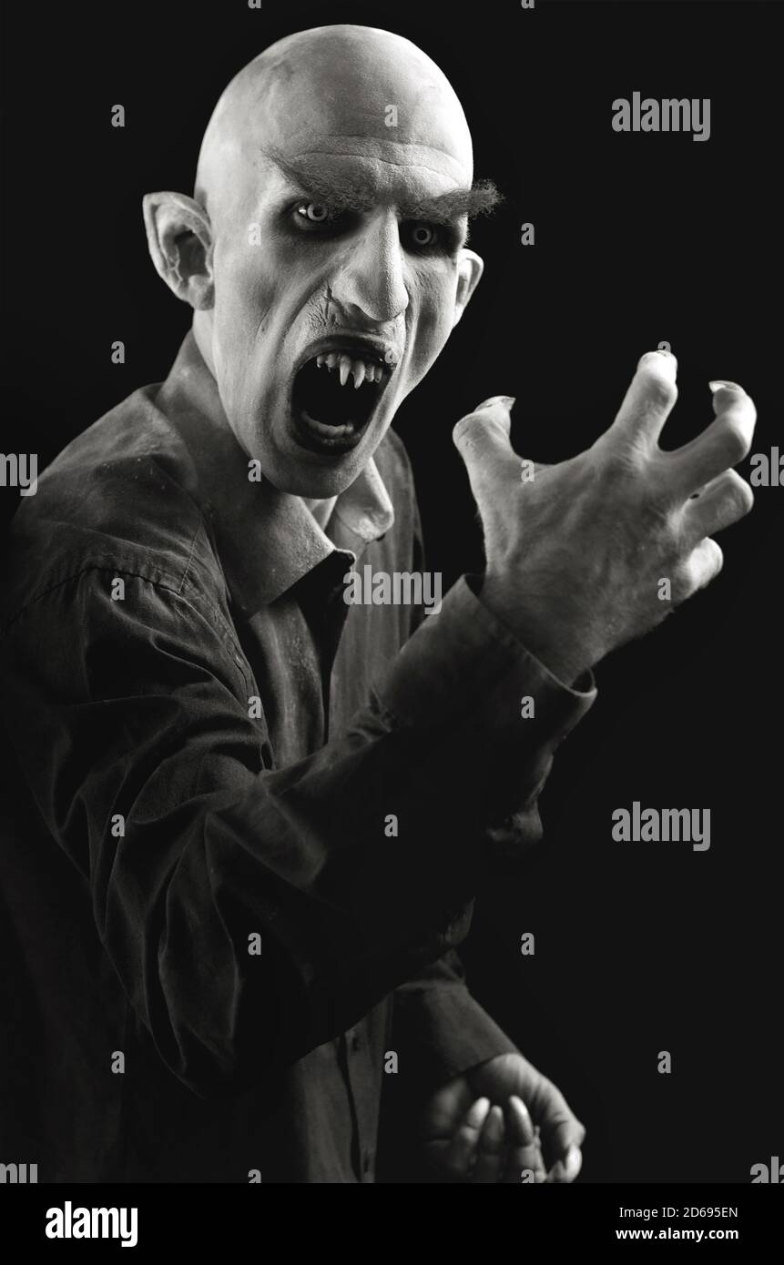 Vertical portrait of a man marked as a vampire on a black background. Stock Photo