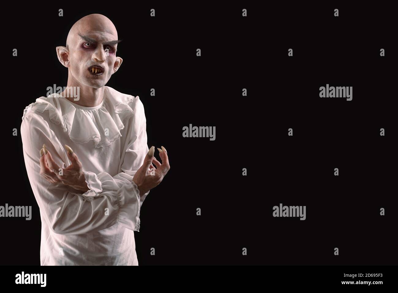Man characterized as a vampire on a black background. Space for text. Stock Photo
