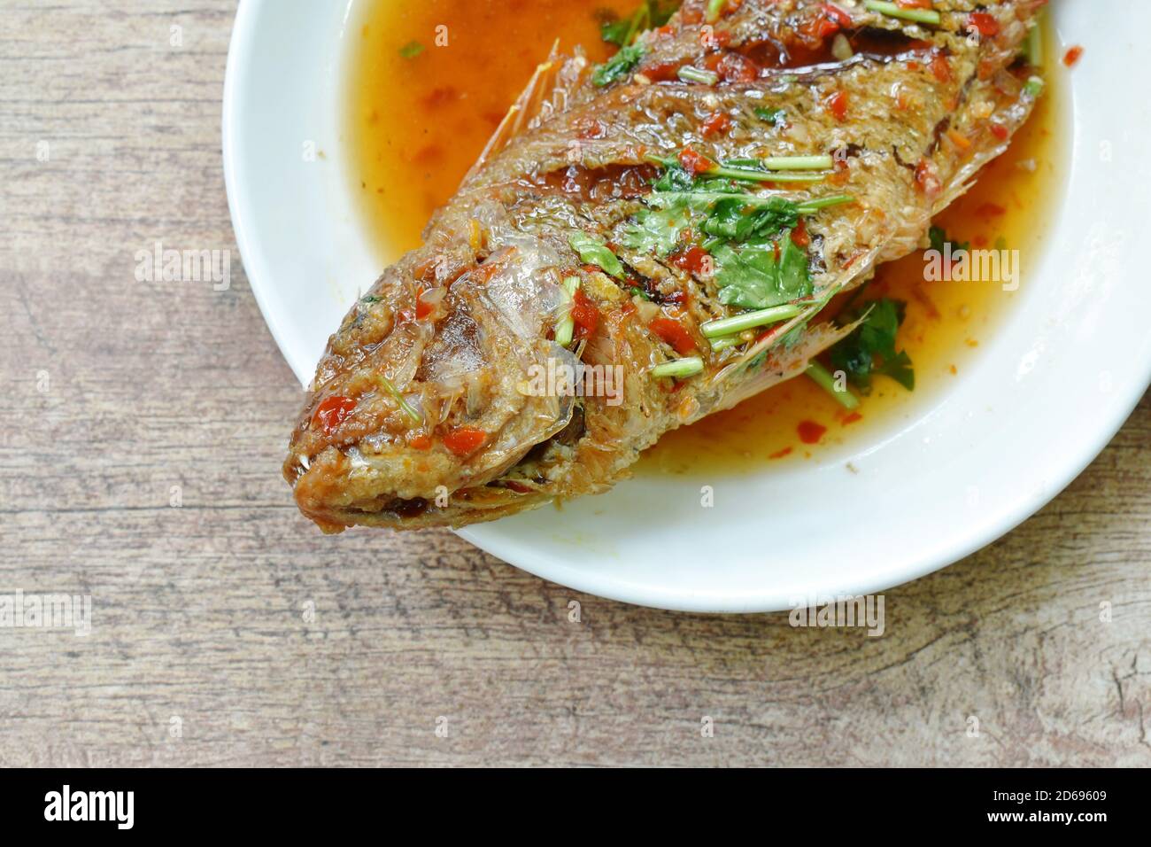deep fried red snapper fish dressing sweet chili sauce on plate Stock