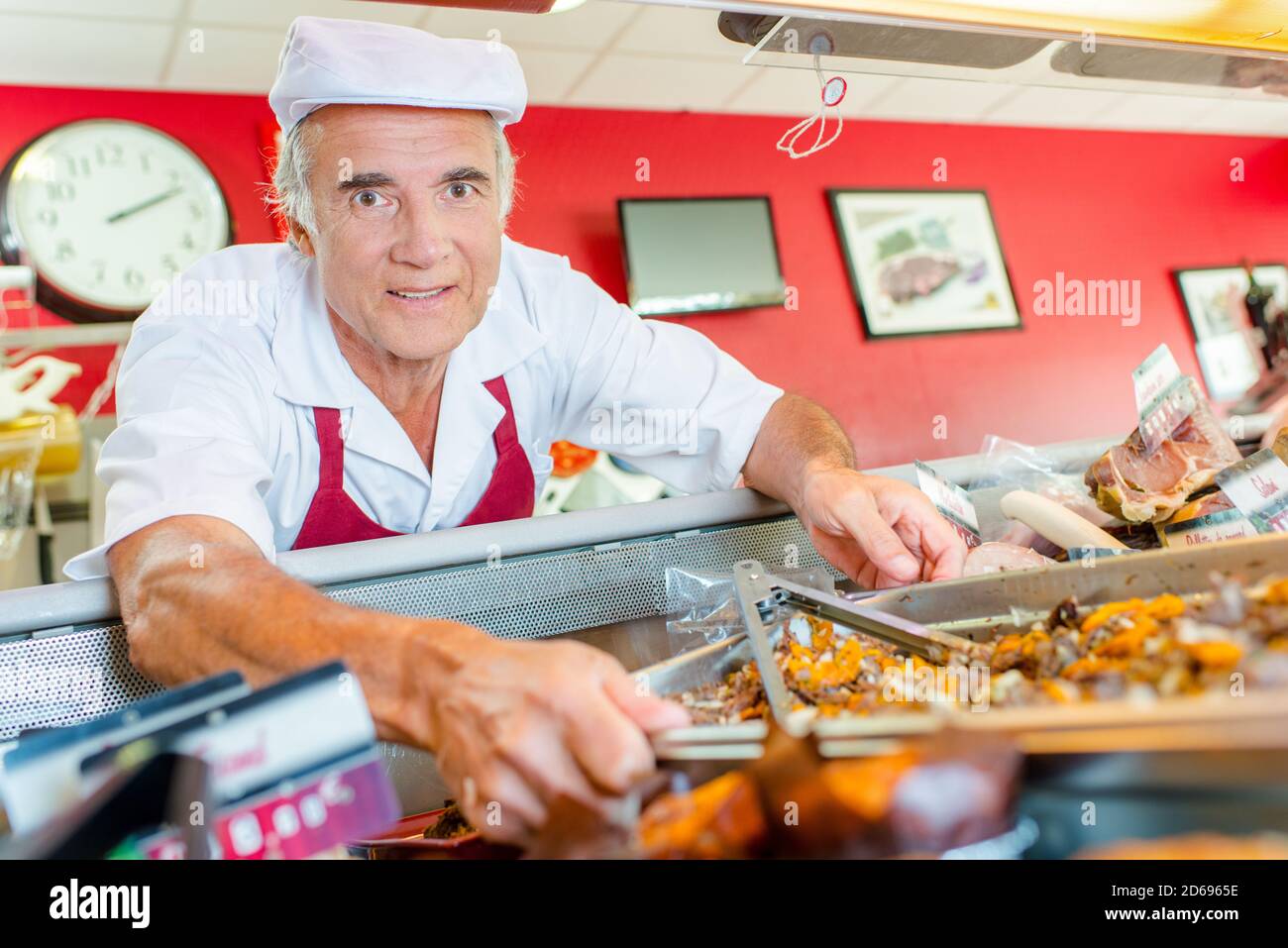 Butcher arranging his deli counter Stock Photo Alamy