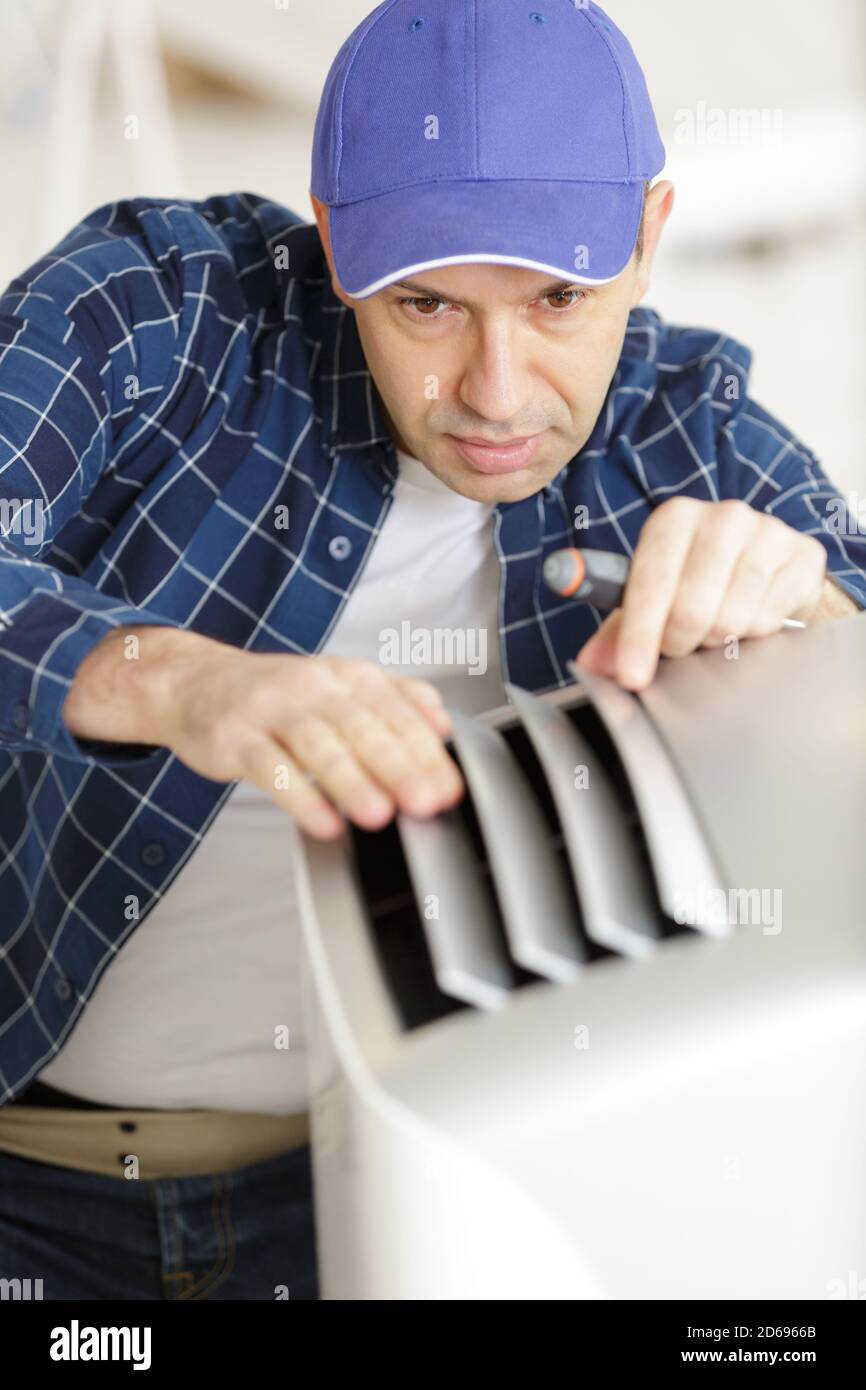 man adjusting the vents on an electrical appliance Stock Photo