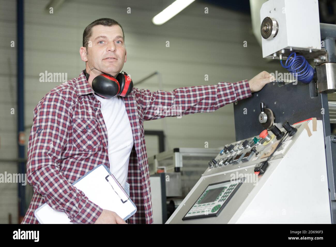 factory engineer operating hydraulic tube bender Stock Photo