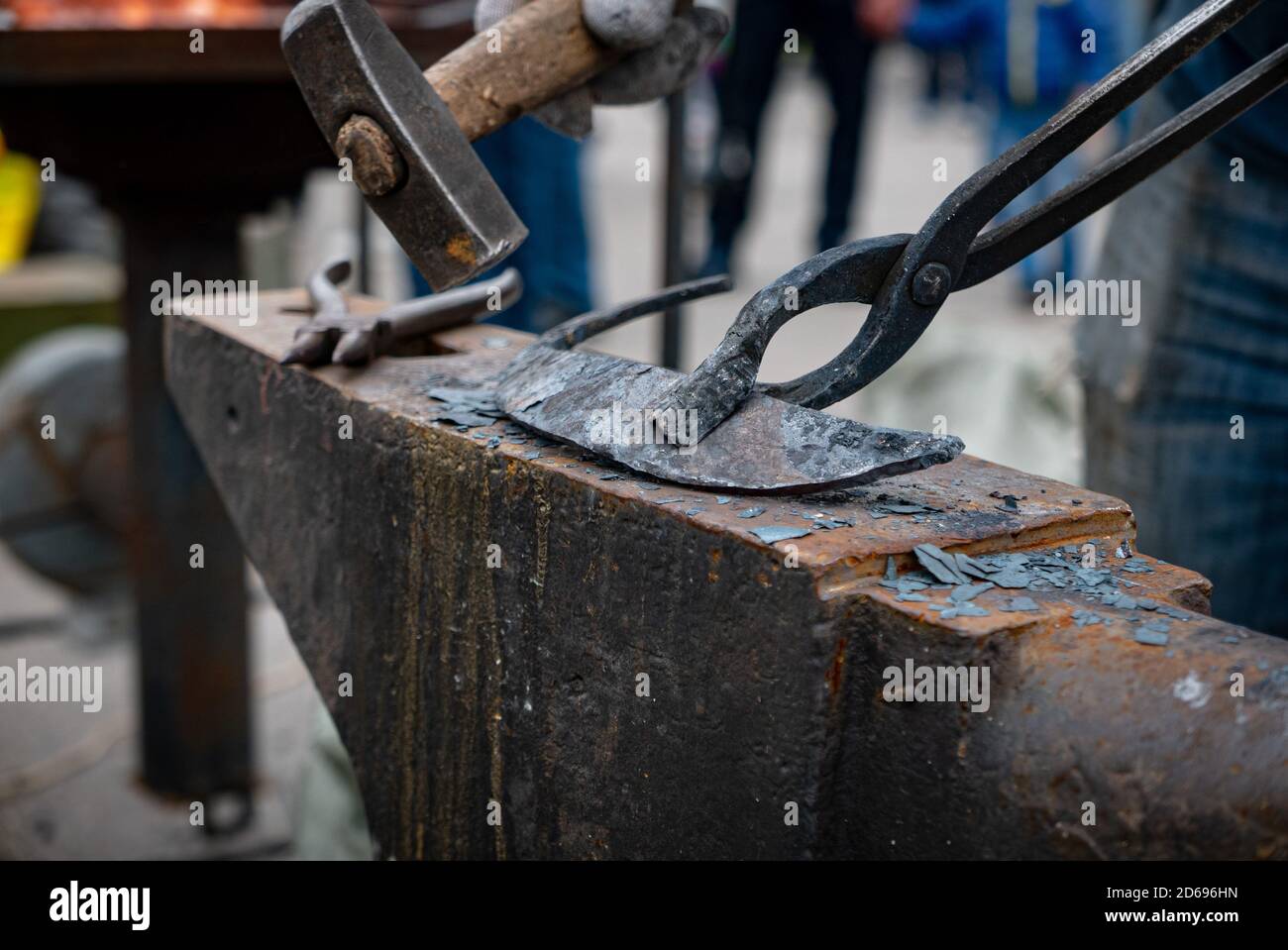 Blacksmith tapping metal detail with a hammer Stock Photo Alamy