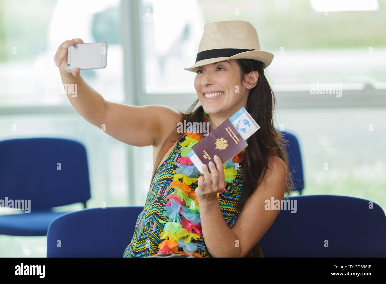 woman taking selfie in airport lounge holding passport Stock Photo - Alamy