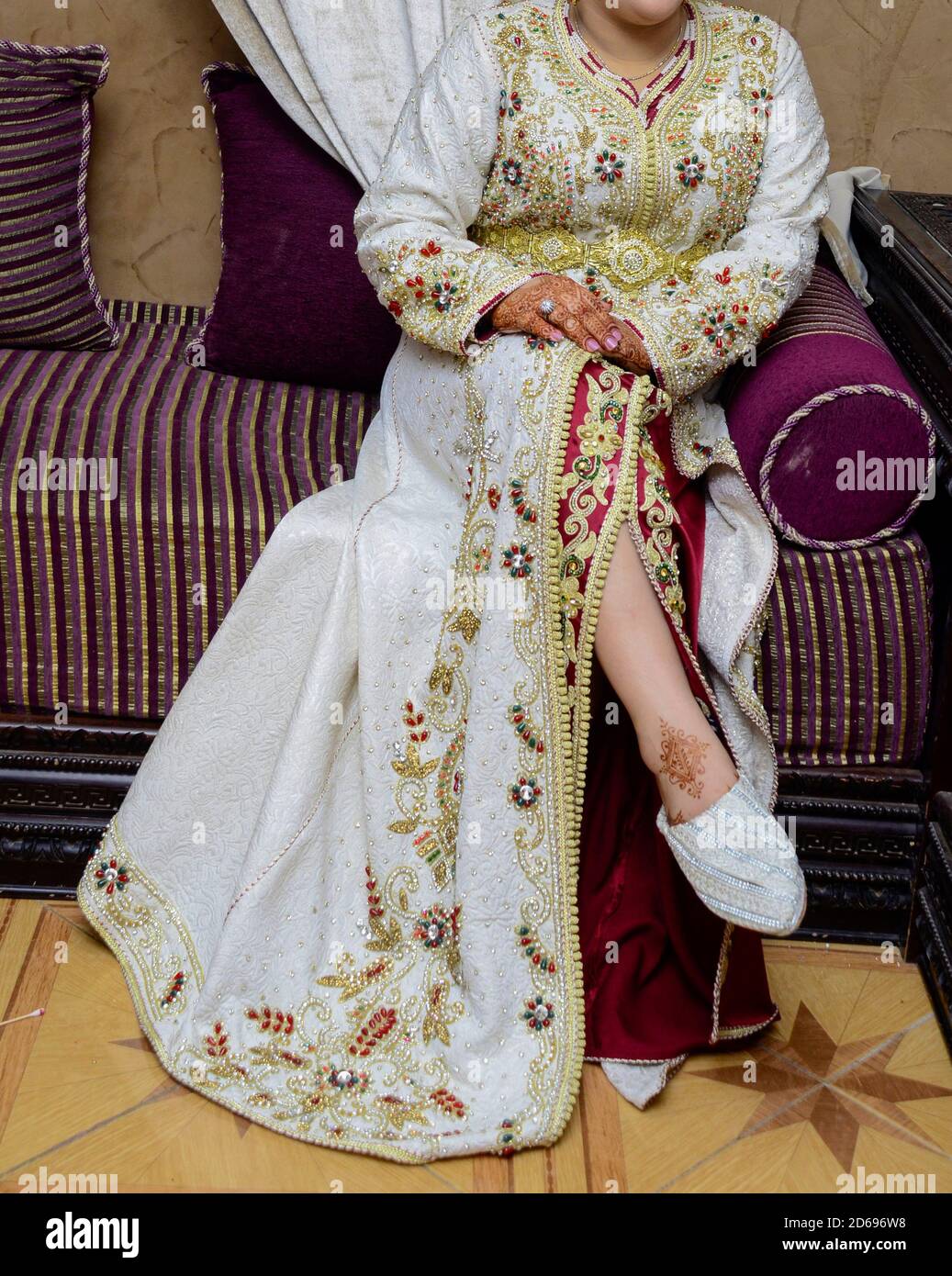 The Moroccan bride sits bug the chair wearing the Moroccan caftan Stock Photo