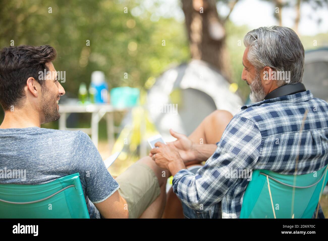 two men sitting on soft chair at camp site Stock Photo