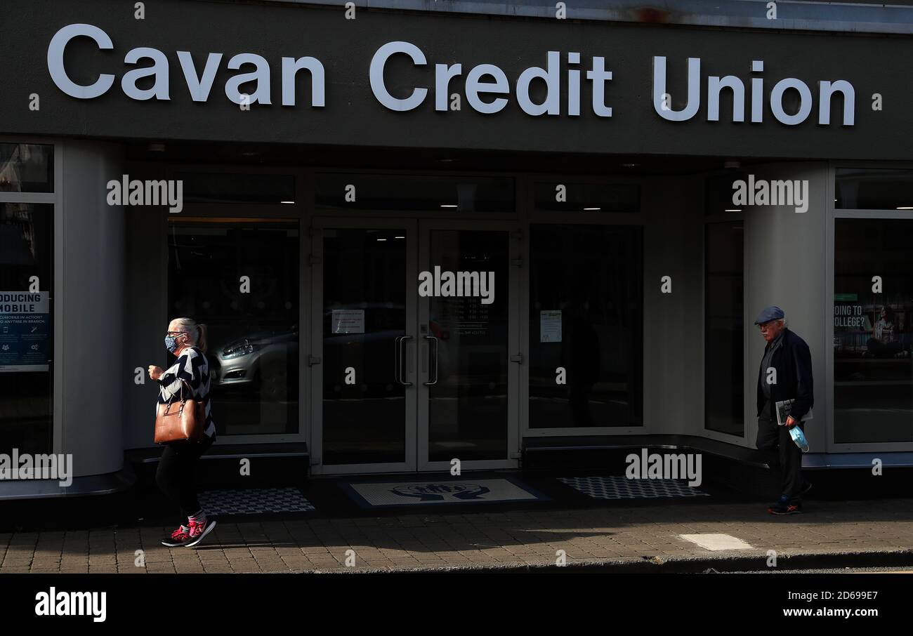 People walk past a credit union on Main street, Co. Cavan, as counties Donegal, Cavan and Monaghan prepare to move to Level 4 of Ireland's Covid-19 plan from midnight tonight. Stock Photo