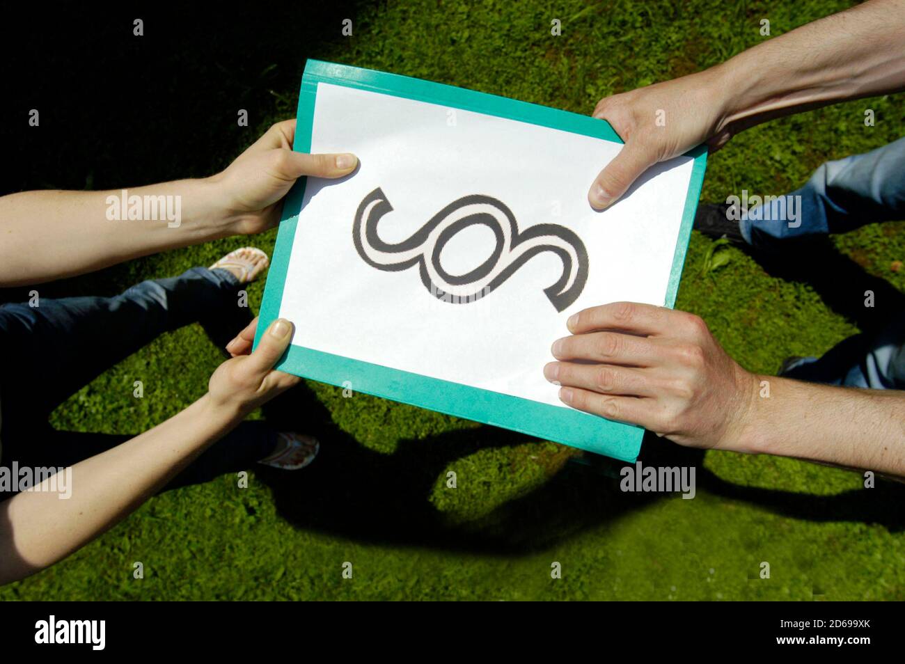 two people pulling on a paper with paragraph sign on it Stock Photo Alamy