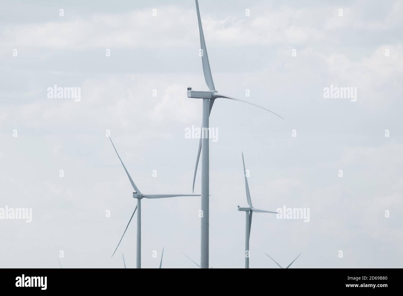 Wind generators farm sustainable industry. Cloudy color graded sky cloudscape with Energy turbines power Stock Photo