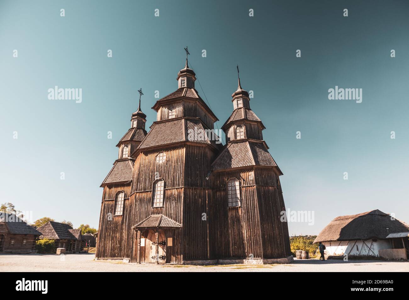 Wooden vintage church full height in Zaporozhian Sich medieval village, state of Cossacks on Khortytsia island, Ukraine. Sunny color graded bright cle Stock Photo