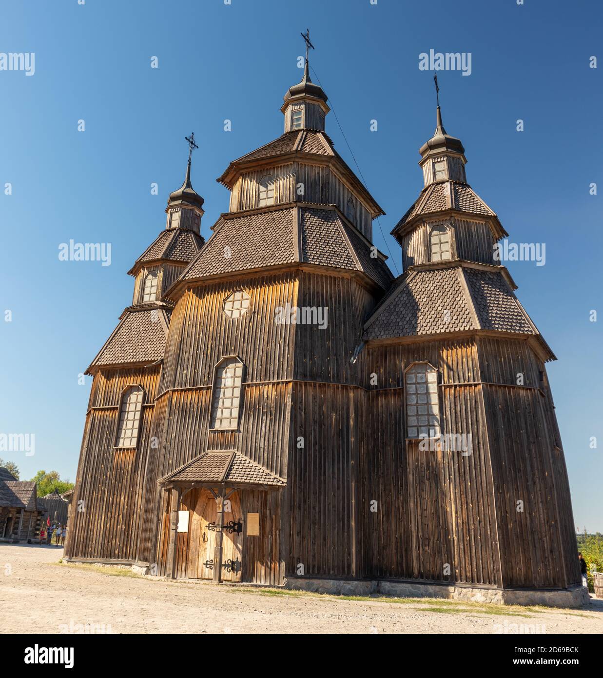 Wooden vintage church full height panorama in Zaporozhian Sich medieval village, state of Cossacks on Khortytsia island, Ukraine. Sunny blue bright cl Stock Photo