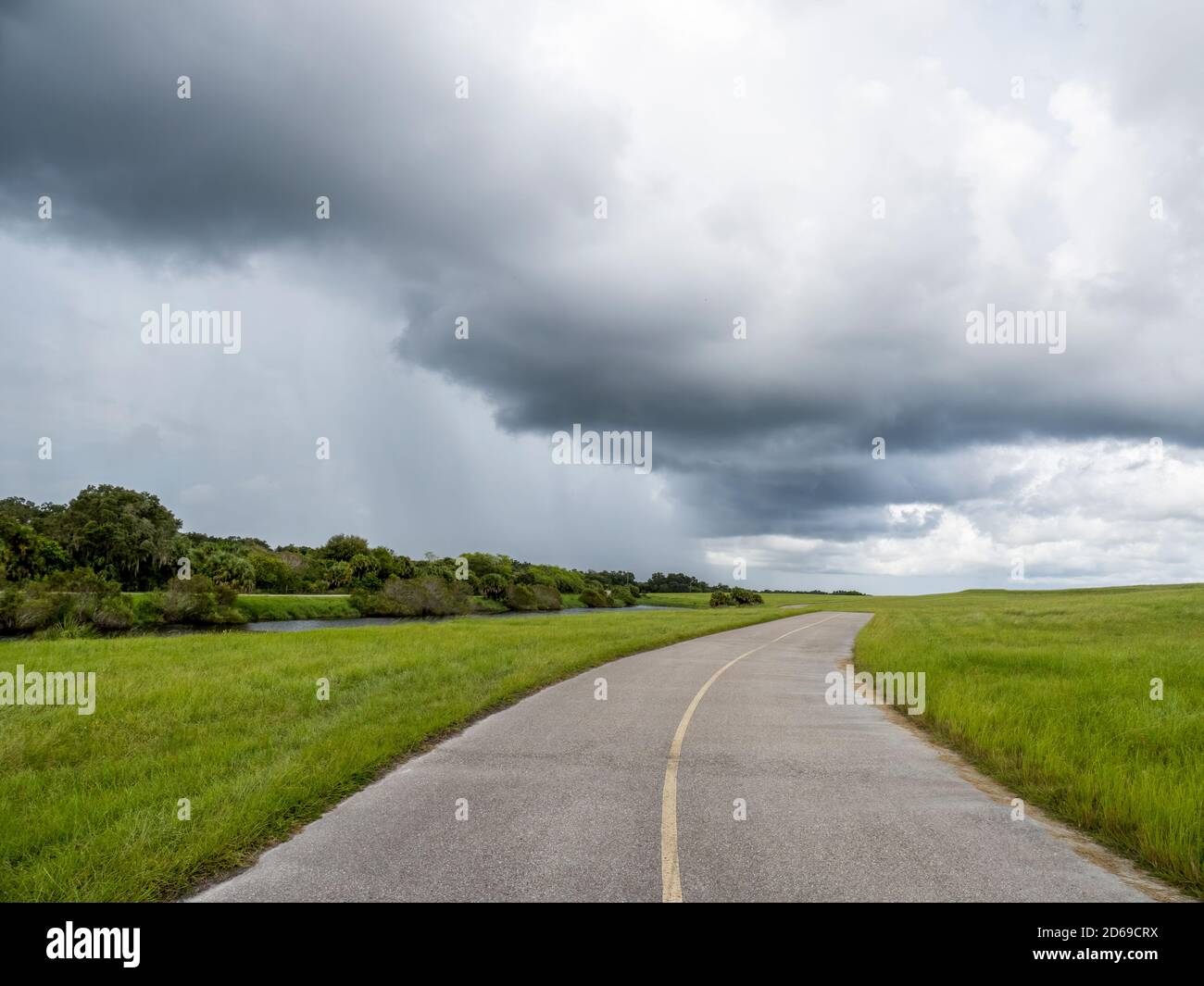 Looking down road at rain storm clouds on the horizon in Southwest Florida Stock Photo