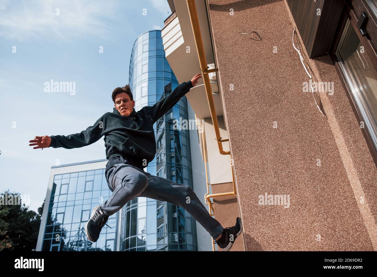 Young man doing parkour in the city at daytime. Conception of extreme sports Stock Photo