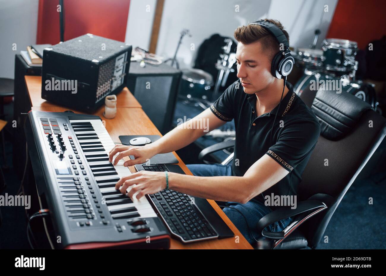 Sound engineer in headphones working and mixing music indoors in the