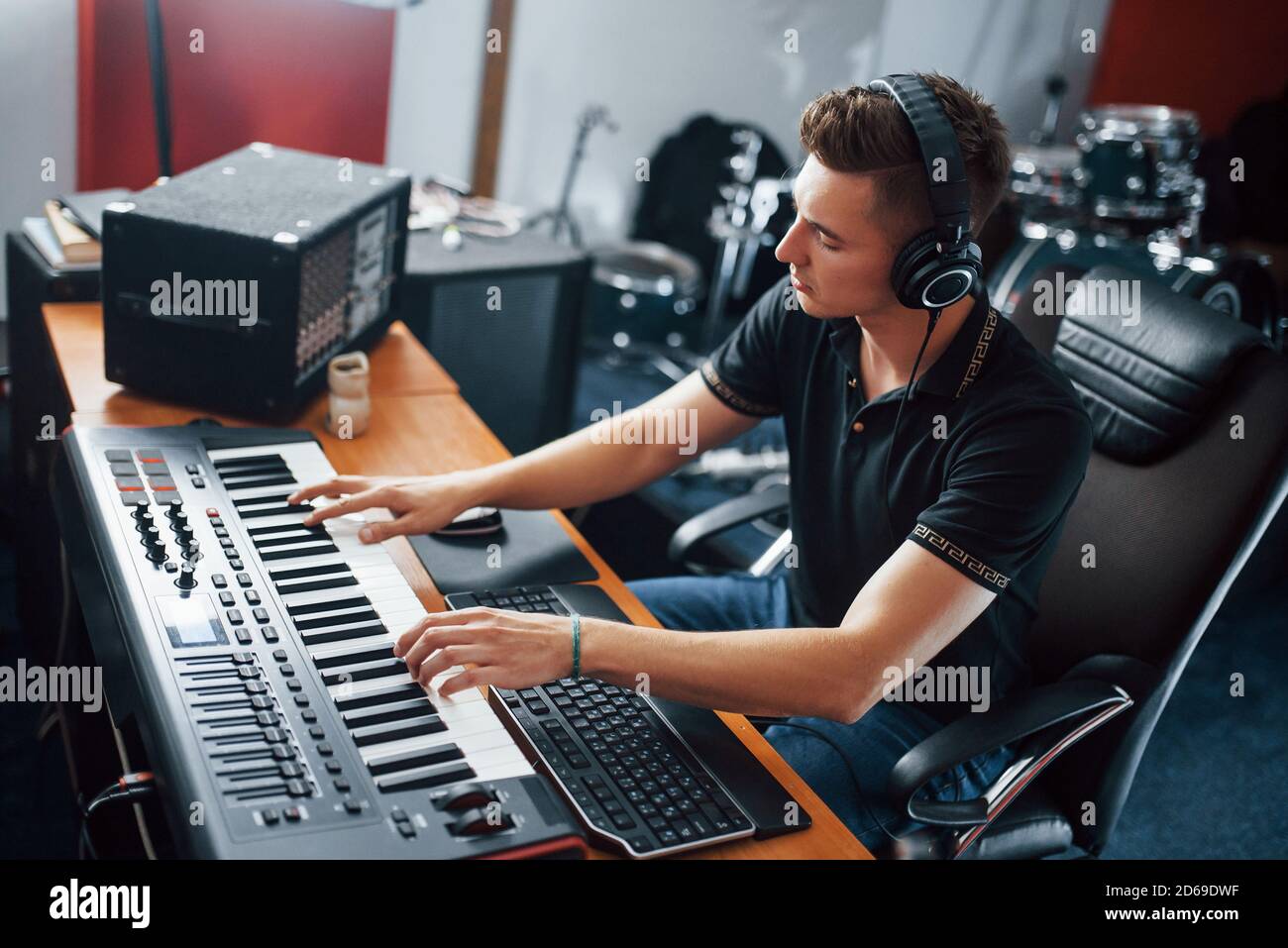 Sound engineer in headphones working and mixing music indoors in the ...
