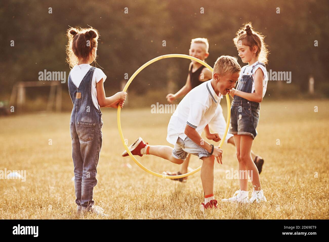 Jumping through the circle fitness tool. Kids having fun in the field ...