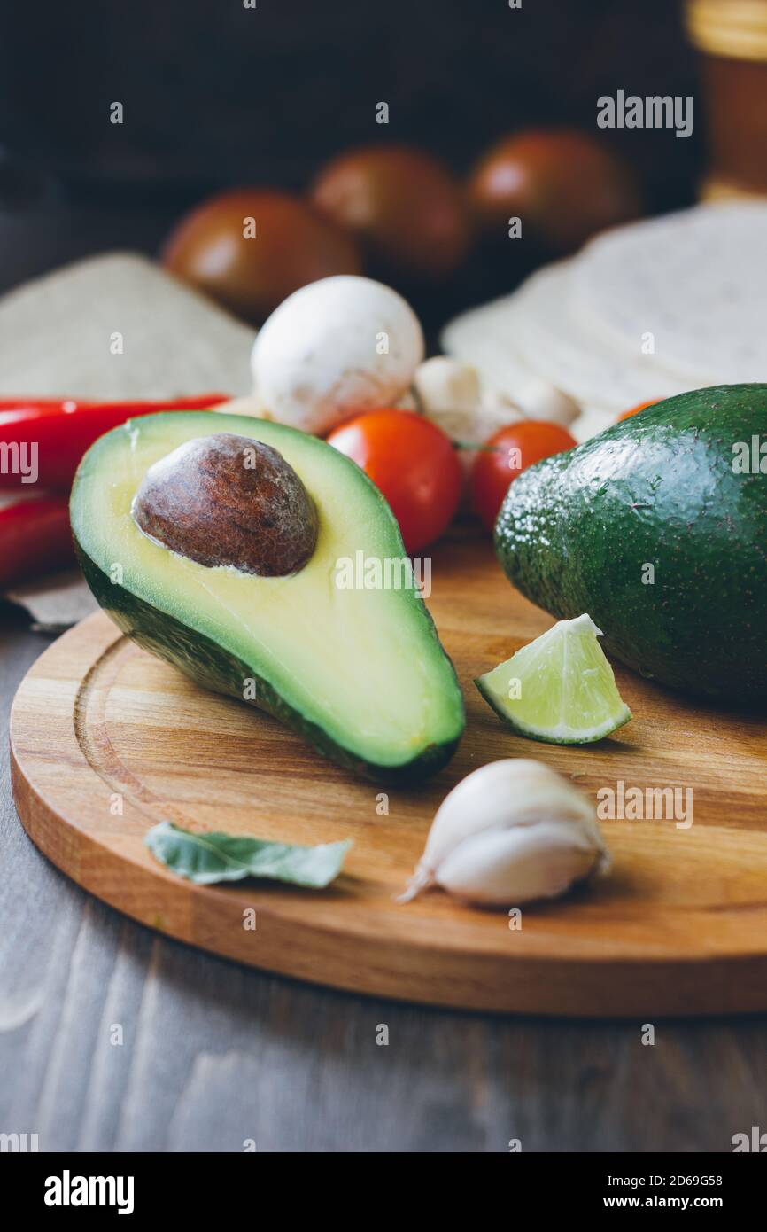 Avocado fruit on wooden board with other vegetables Stock Photo - Alamy