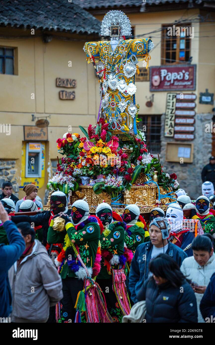 Religious procession, dancers dressed in colorful costumes carrying cross depicting the Senor de Choquekilca, Ollantaytambo, Cusco, Peru Stock Photo