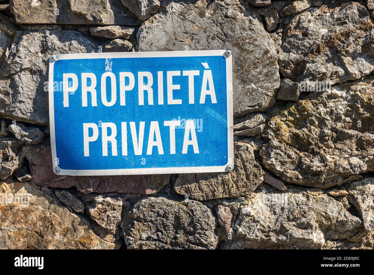 Proprieta Privata, Blue and white Private Property sign in Italian language hanging on a stone wall. Liguria, Italy, Europe Stock Photo