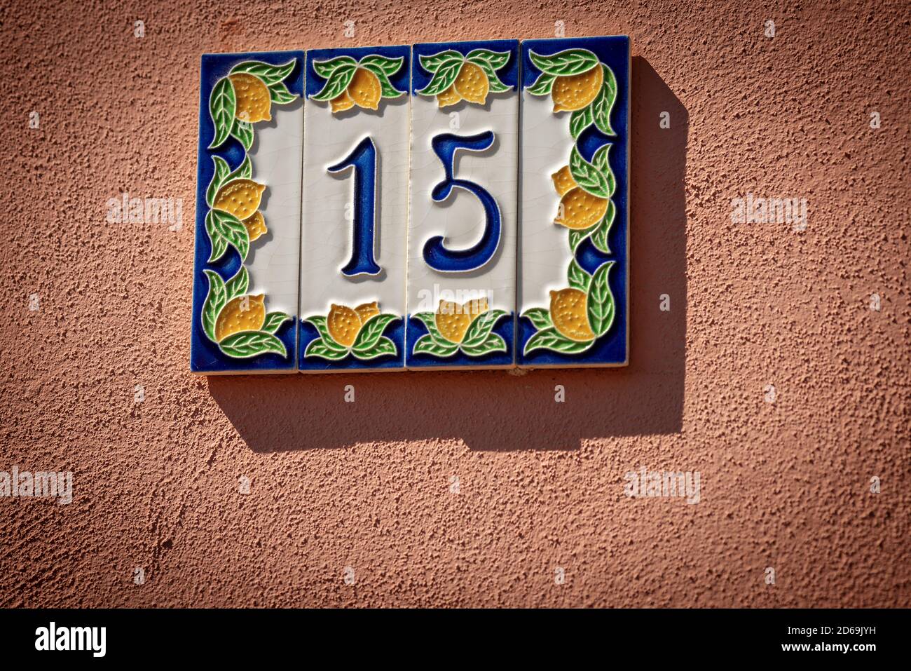 Close-up of house number 15 (fifteen), made of ceramic, on the red wall in a small village. Liguria, Italy, Europe Stock Photo